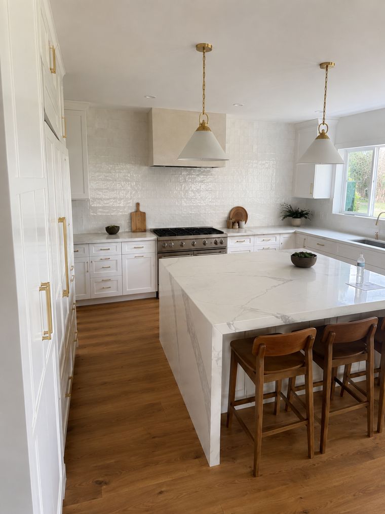 Island and range wall with handmade white tile carried to the ceiling