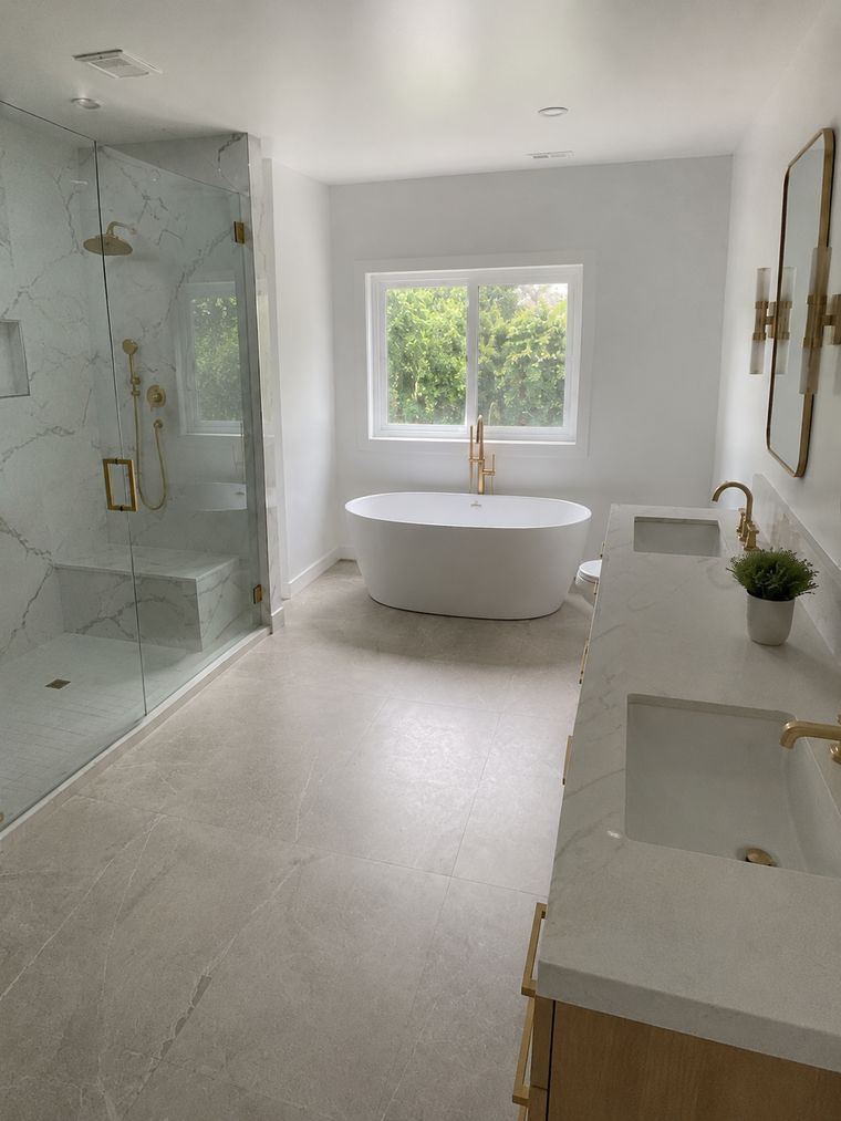 Freestanding tub below the window with the shower enclosure alongside