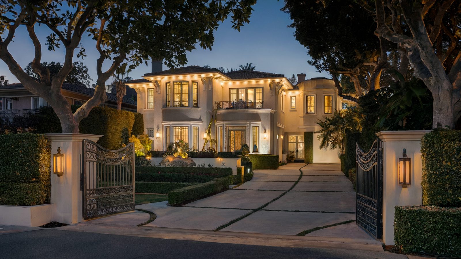 Hillside estate home lit at night after renovation